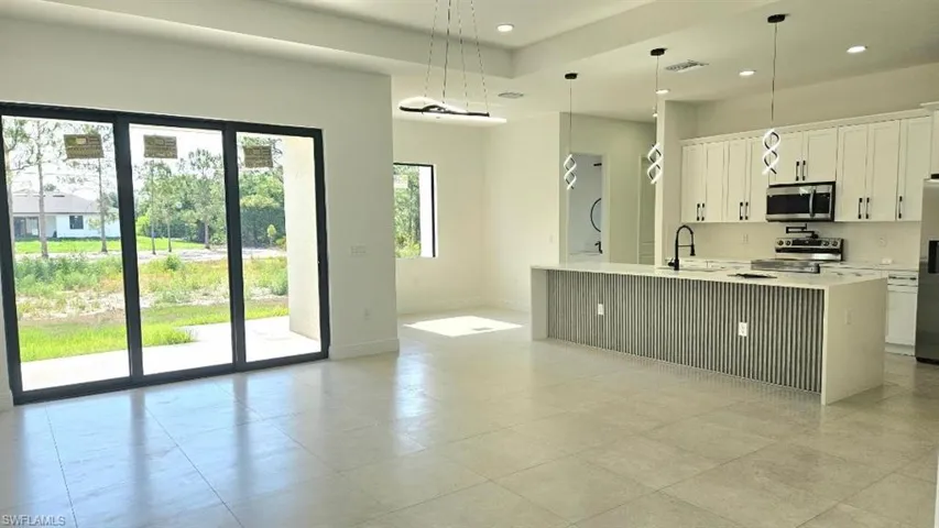 Kitchen featuring appliances with stainless steel finishes, baseboards, light countertops, white cabinets, and recessed lighting