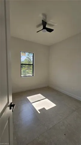 Empty room with baseboards and ceiling fan