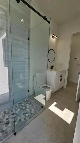 Full bathroom featuring a stall shower, toilet, and vanity