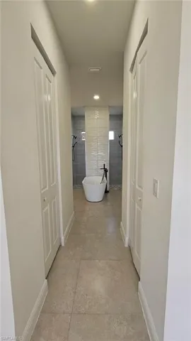 Corridor with baseboards and recessed lighting