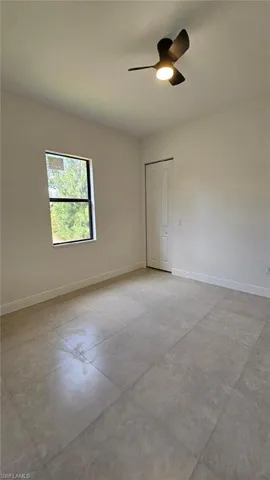 Unfurnished room with baseboards, a ceiling fan, and concrete floors