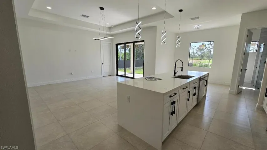 Kitchen featuring a sink, plenty of natural light, baseboards, dishwasher, and recessed lighting