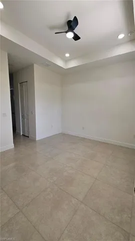 Spare room featuring baseboards, recessed lighting, ceiling fan, light tile patterned floors, and a smoke detector