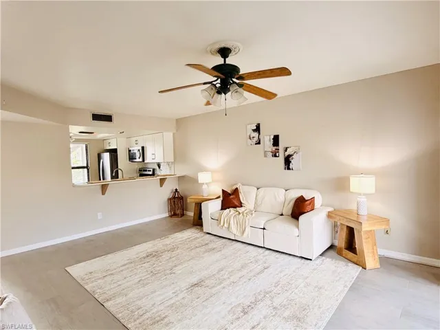 Living room featuring ceiling fan and baseboards