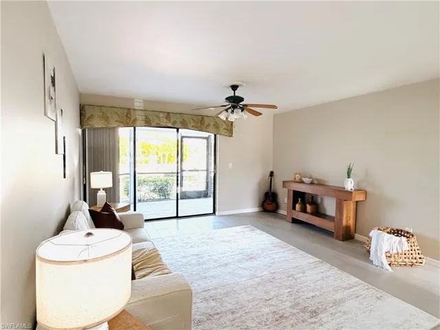 Living area featuring ceiling fan and baseboards