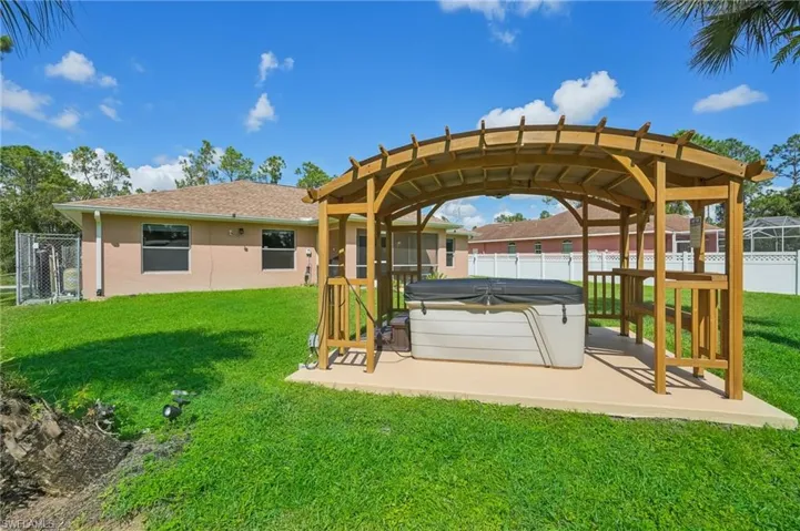 Dock featuring a fenced backyard, a hot tub, and a patio area