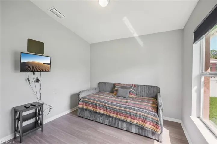 Bedroom featuring wood finished floors and lofted ceiling