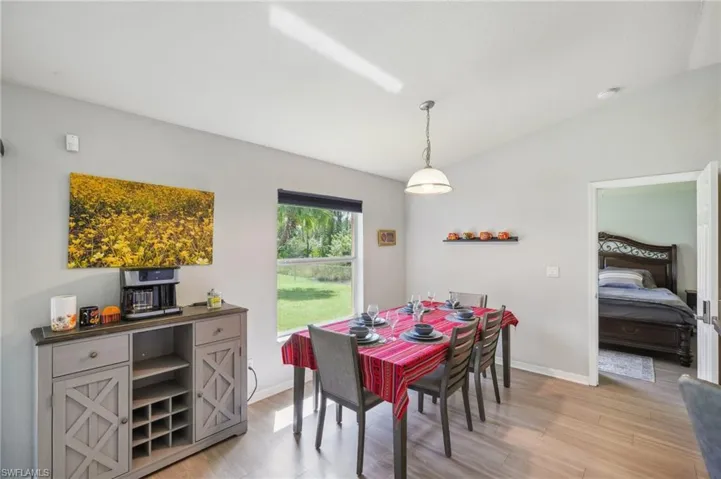 Dining room with vaulted ceiling and light wood-style floors