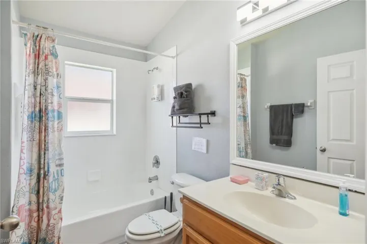 Bathroom featuring shower / tub combo with curtain and vanity