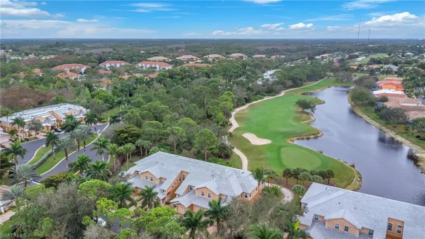 Aerial overview of property's location featuring a large body of water, nearby suburban area, and a golf club