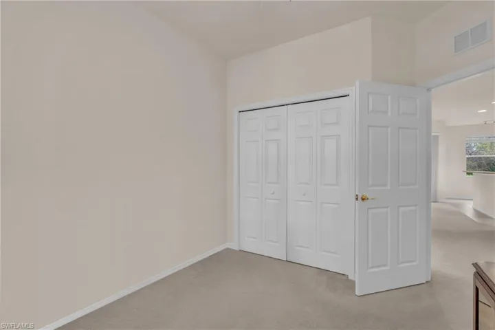 Unfurnished bedroom with light carpet and a closet