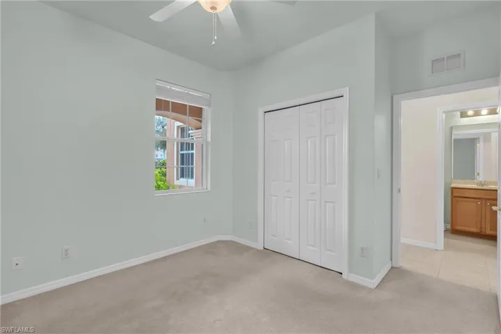 Unfurnished bedroom with light carpet, a closet, and ceiling fan