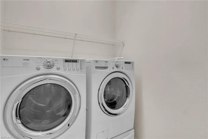 Laundry area featuring washer and clothes dryer and a textured wall