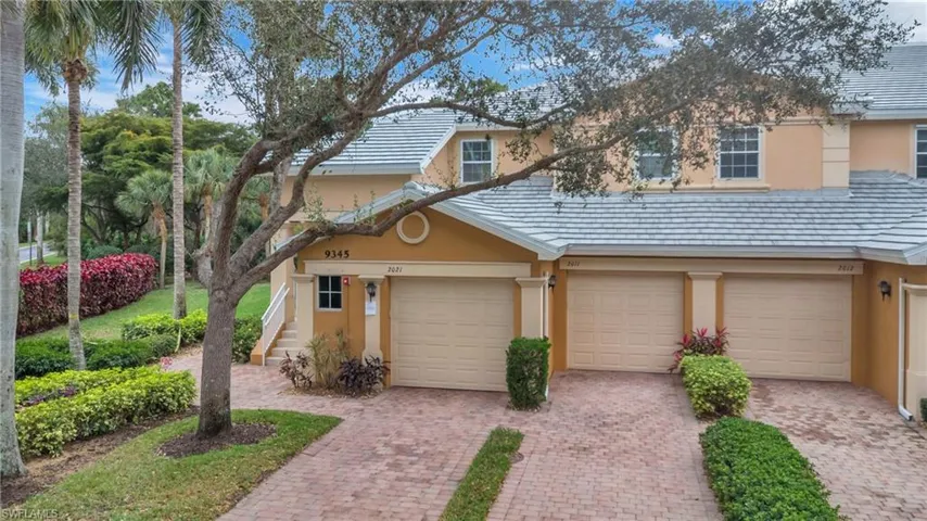Traditional-style home featuring stucco siding, a garage, and decorative driveway