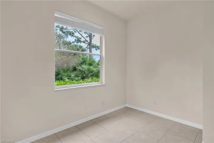Empty room featuring baseboards and light tile patterned floors