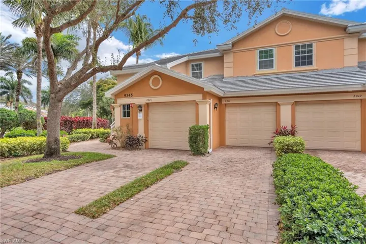 Traditional home featuring stucco siding and decorative driveway