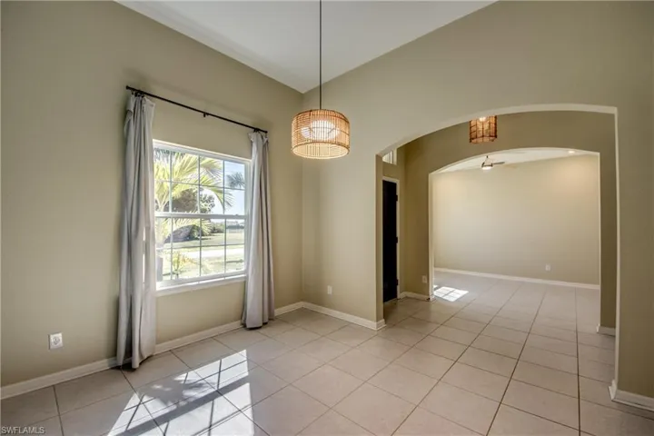 Unfurnished room featuring light tile patterned floors and arched walkways
