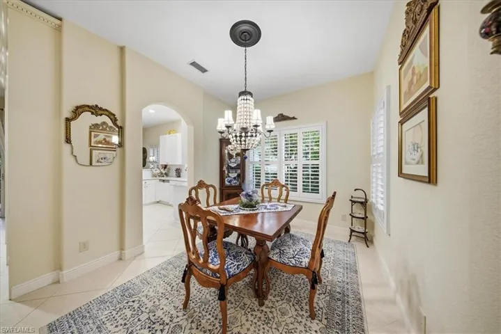 Dining space featuring a chandelier, arched walkways, and light tile patterned floors