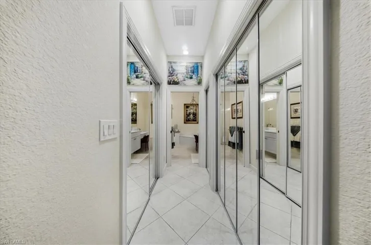 Corridor featuring a textured wall and light tile patterned flooring