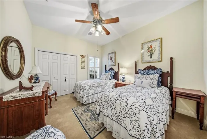 Bedroom with light carpet, a ceiling fan, and a closet