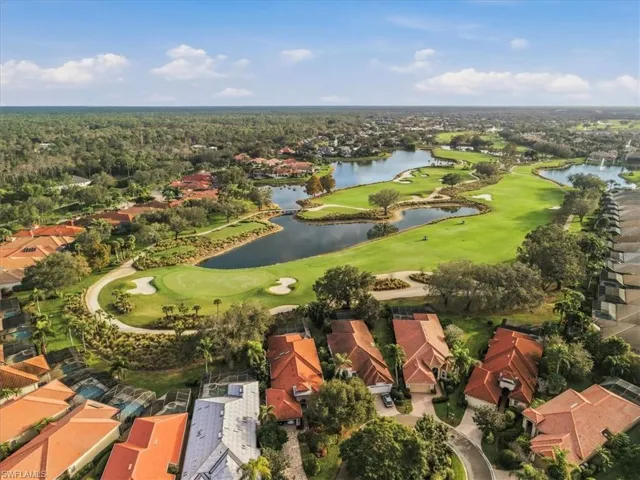 Aerial view of property's location featuring a golf club and nearby suburban area