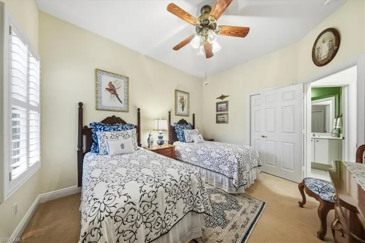 Bedroom with light colored carpet, a ceiling fan, and a closet