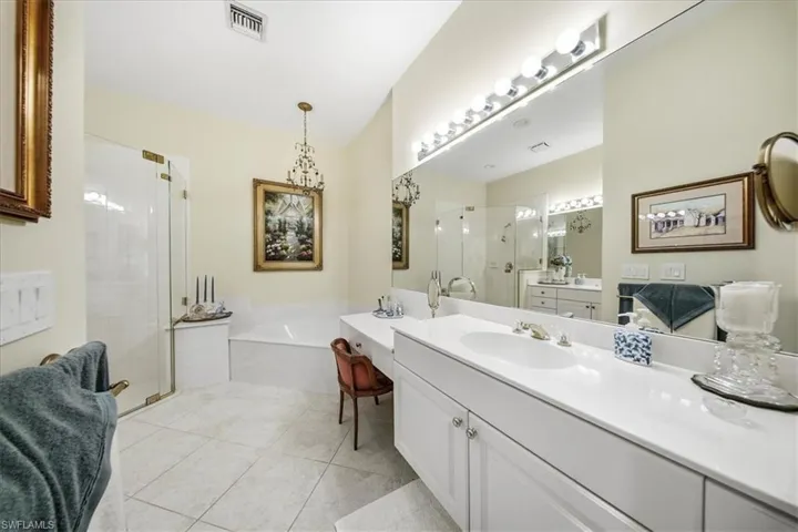 Full bath with a stall shower, a garden tub, vanity, and light tile patterned floors