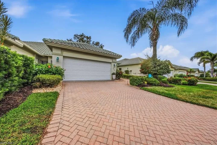 Ranch-style house featuring stucco siding, decorative driveway, and an attached garage