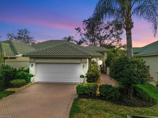 View of front of house with stucco siding, decorative driveway, a tile roof, and an attached garage