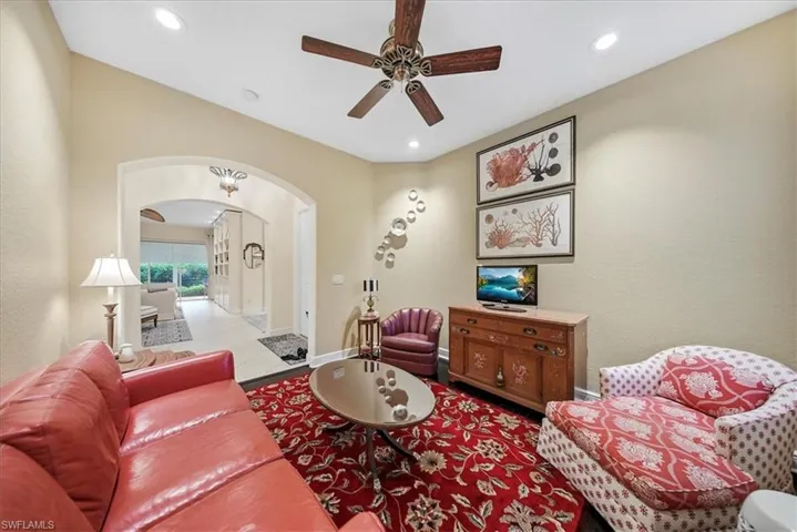Living room with arched walkways and a ceiling fan