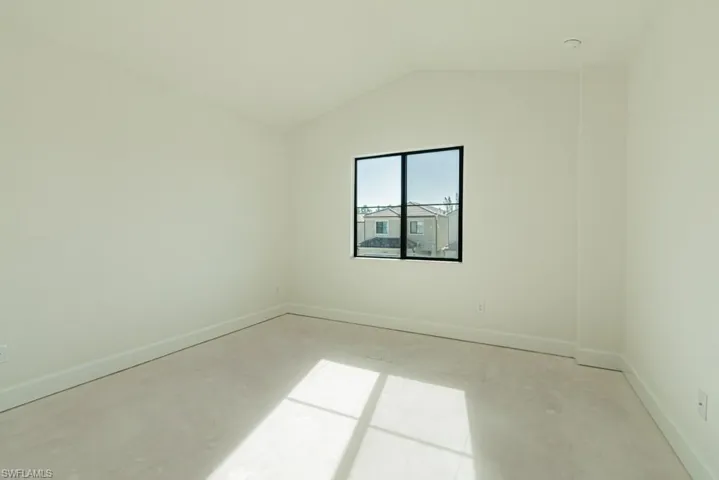 Empty room with vaulted ceiling