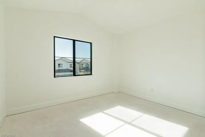 Unfurnished room with lofted ceiling