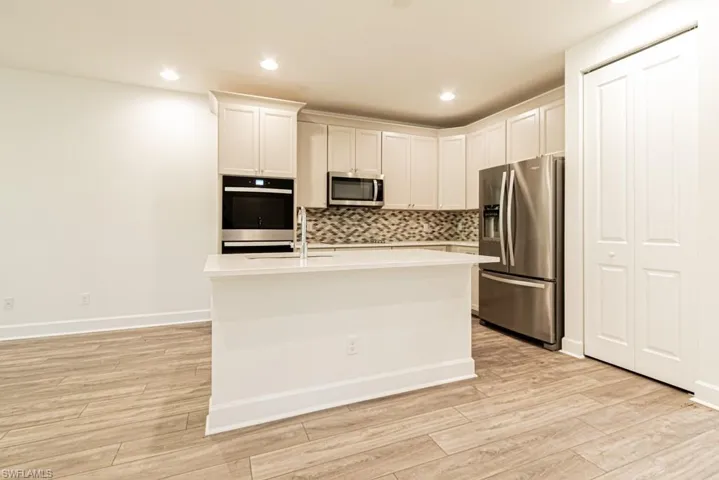 Kitchen featuring white cabinetry, sink, light hardwood / wood-style floors, and appliances with stainless steel finishes