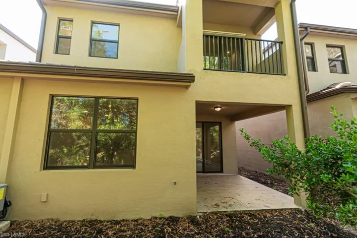 Back of house with a patio area and a balcony