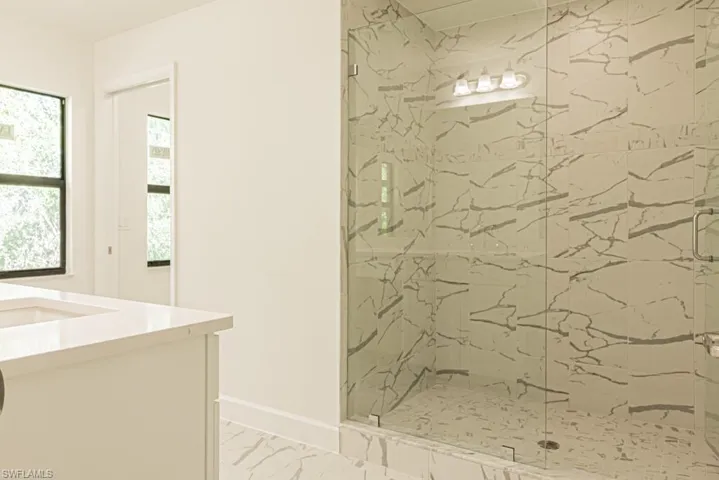 Bathroom with a wealth of natural light, vanity, and walk in shower