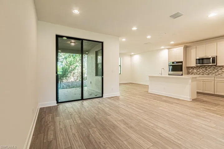 Unfurnished living room with light hardwood / wood-style flooring and sink