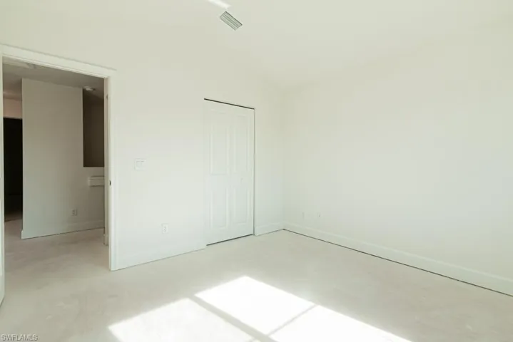 Unfurnished bedroom with a closet and lofted ceiling