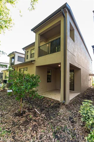 Rear view of house with a balcony and a patio