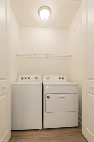 Laundry area featuring hardwood / wood-style flooring and washer and clothes dryer