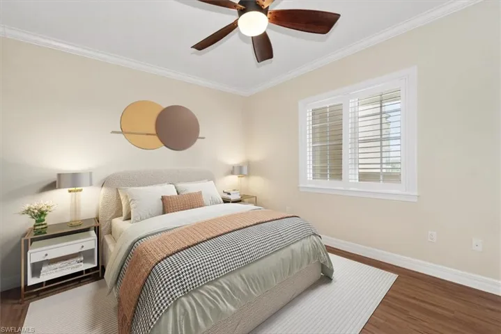 Bedroom featuring crown molding, dark wood finished floors, and a ceiling fan