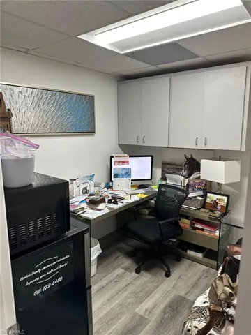 Office space featuring light wood-type flooring and a paneled ceiling
