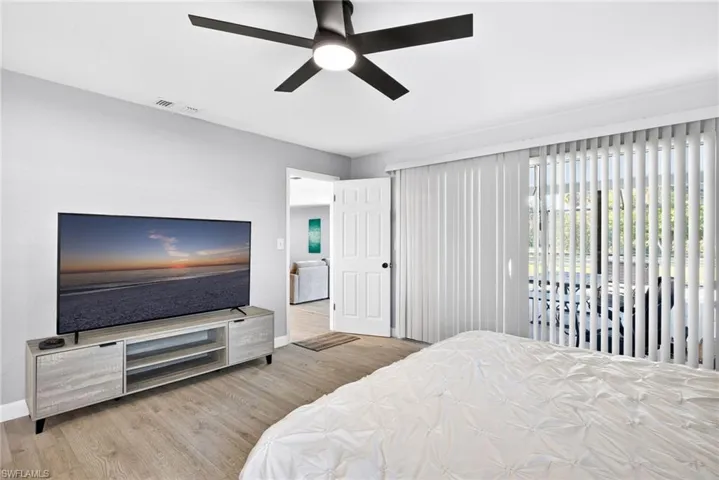 Bedroom featuring access to exterior, light wood-type flooring, and ceiling fan