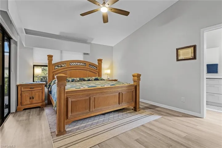 Bedroom featuring lofted ceiling, ensuite bathroom, ceiling fan, and light hardwood / wood-style floors