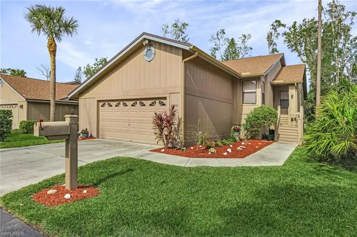 View of front of property featuring a garage and a front lawn