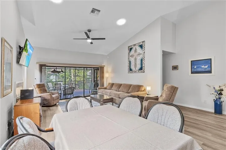 Dining room with ceiling fan, light hardwood / wood-style floors, and lofted ceiling