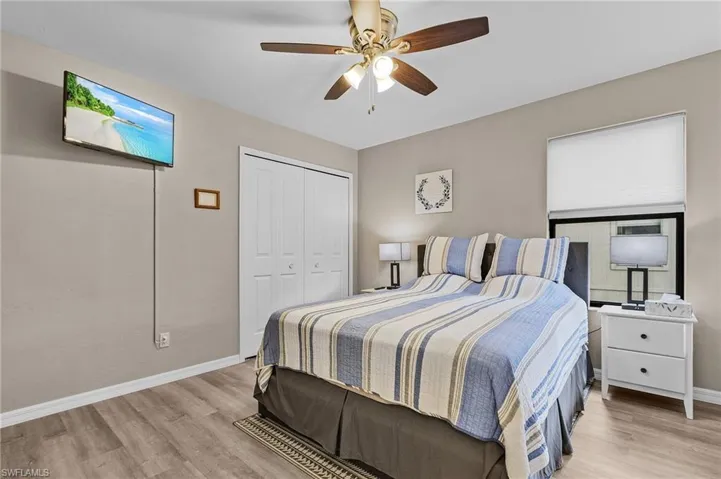 Bedroom featuring ceiling fan, a closet, and light wood-type flooring