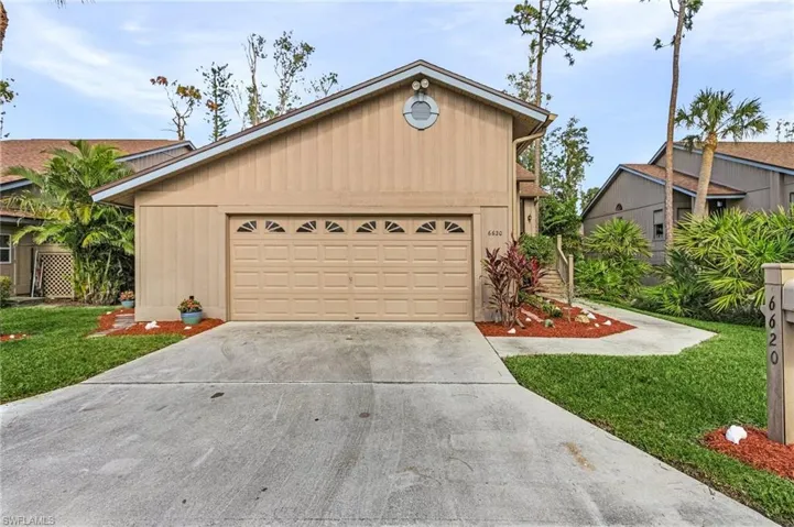 View of front of home with a front yard and a garage