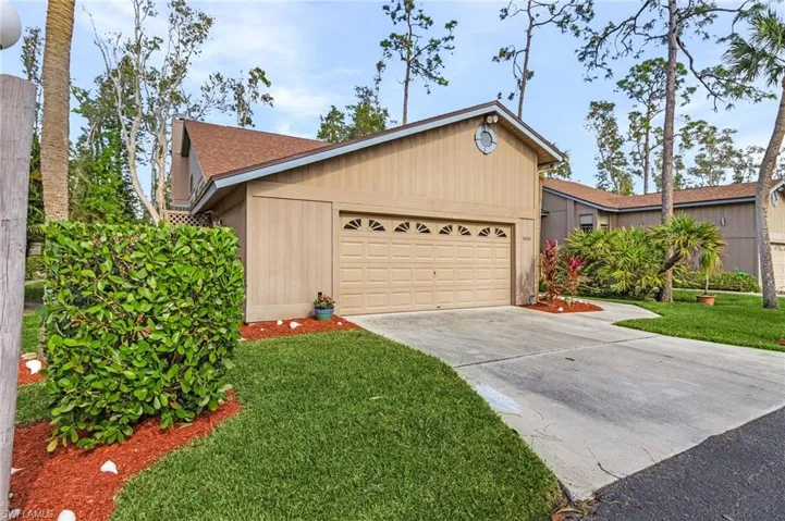 Ranch-style house with a garage and a front lawn