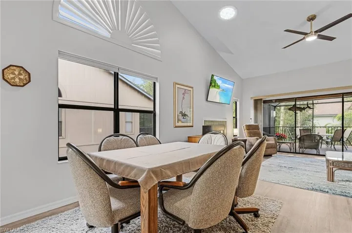 Dining space with light wood-type flooring, high vaulted ceiling, and ceiling fan