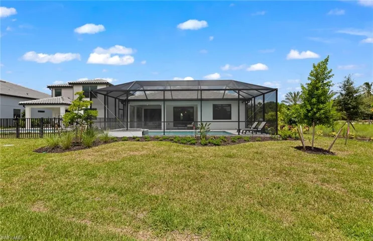 Rear view of property featuring an outdoor pool, and lanai